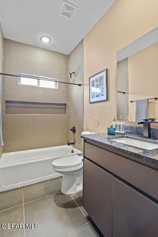 full bath with visible vents, toilet, tile patterned floors, vanity, and  shower combination