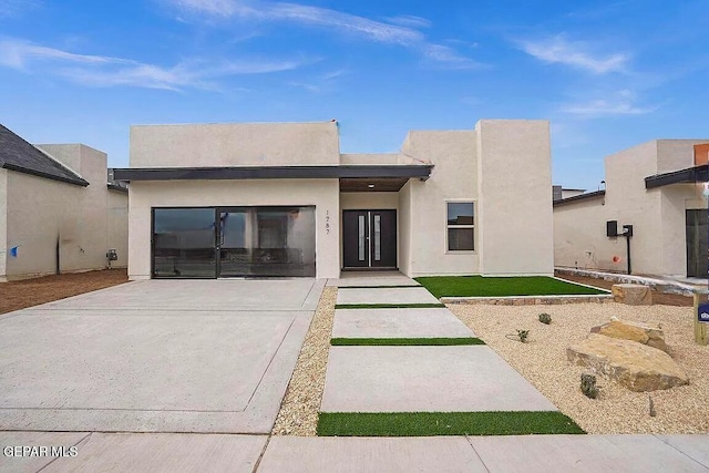 contemporary house featuring stucco siding and driveway
