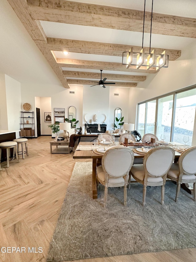 dining room with beam ceiling, ceiling fan, and a towering ceiling
