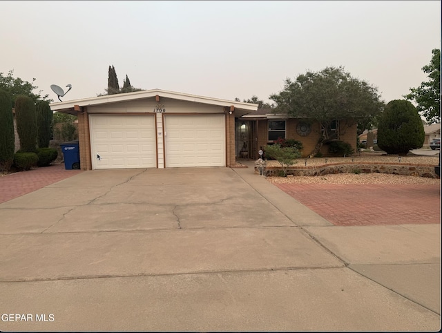 single story home featuring decorative driveway and an attached garage