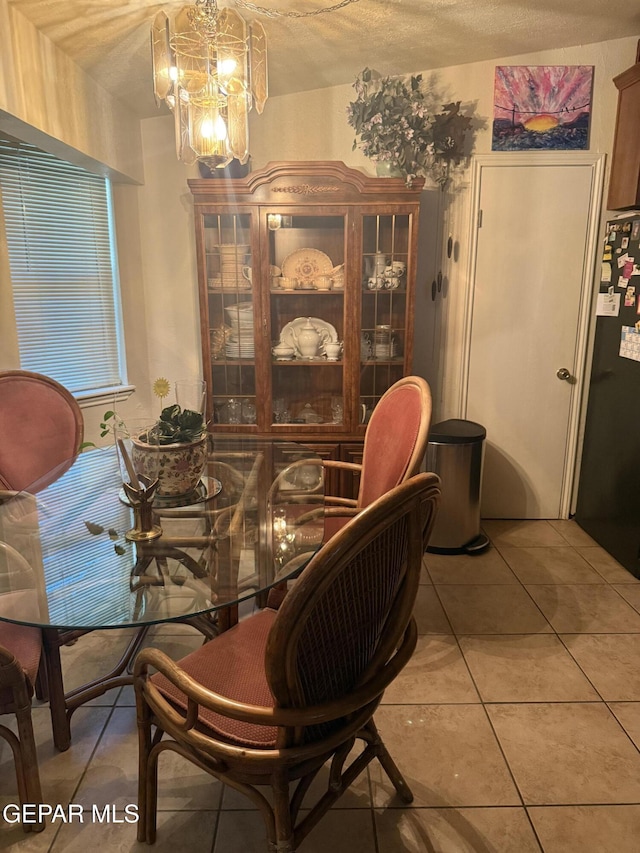 dining space featuring light tile patterned floors and a notable chandelier