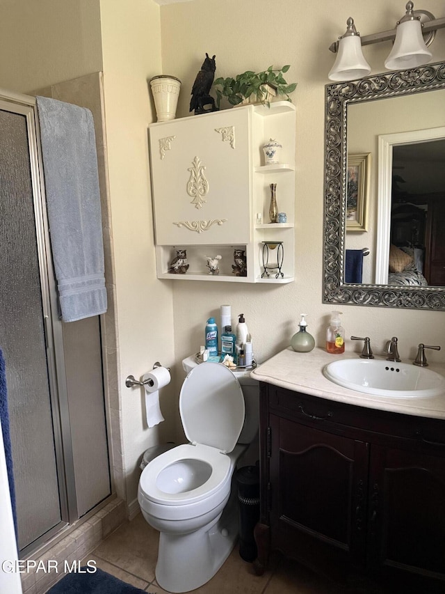 bathroom with vanity, tile patterned flooring, a shower stall, and toilet