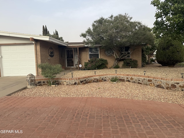 ranch-style house with an attached garage, driveway, and brick siding