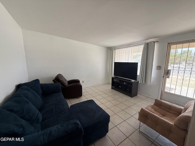 living area featuring light tile patterned floors and baseboards