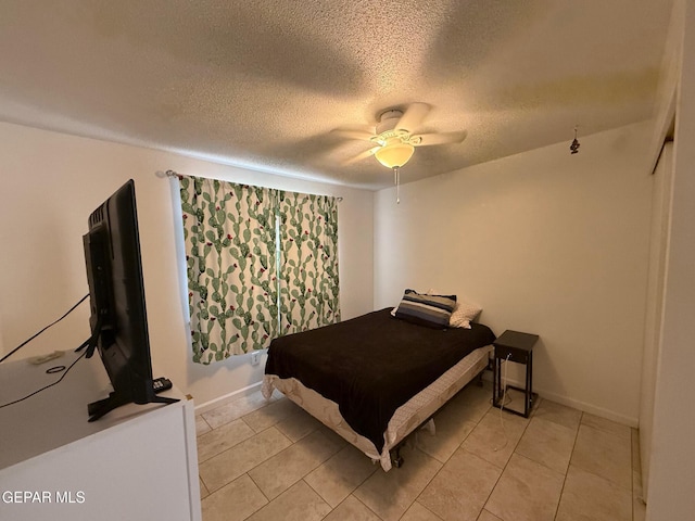 bedroom with a textured ceiling, a ceiling fan, light tile patterned flooring, and baseboards