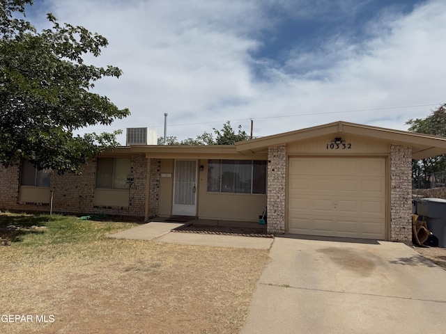 ranch-style house featuring driveway, an attached garage, and brick siding