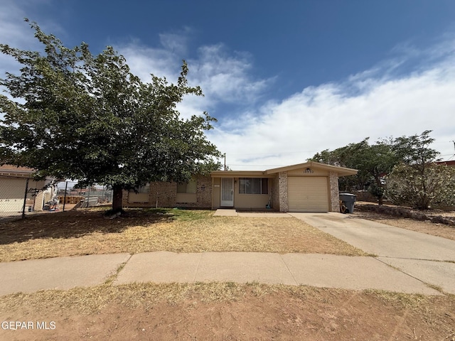 view of front of home featuring concrete driveway, brick siding, an attached garage, and fence