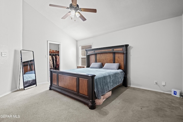carpeted bedroom featuring a walk in closet, vaulted ceiling, baseboards, ceiling fan, and a closet