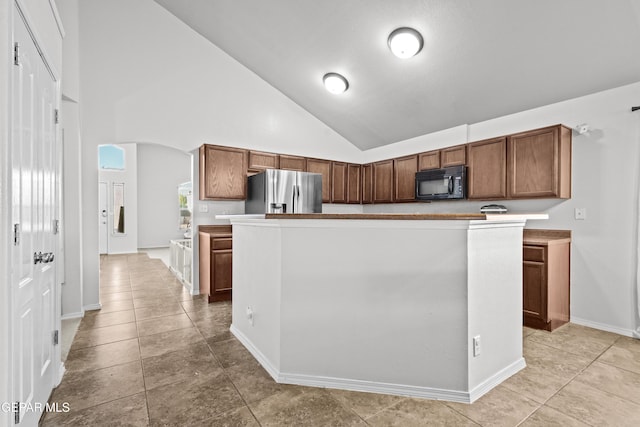 kitchen with black microwave, stainless steel fridge with ice dispenser, arched walkways, high vaulted ceiling, and baseboards