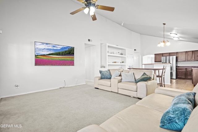 living area with high vaulted ceiling, a chandelier, baseboards, a ceiling fan, and light colored carpet