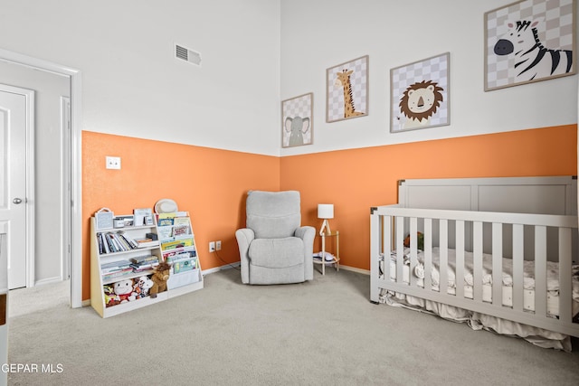 bedroom with a nursery area, carpet, baseboards, and a towering ceiling