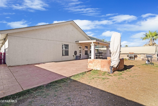 rear view of house with a patio area and stucco siding