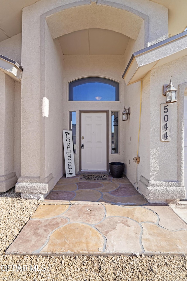 doorway to property featuring stucco siding