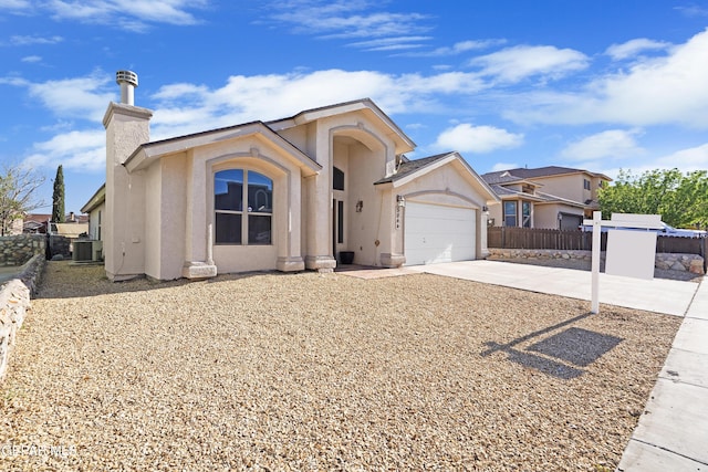ranch-style house with stucco siding, driveway, an attached garage, fence, and a chimney