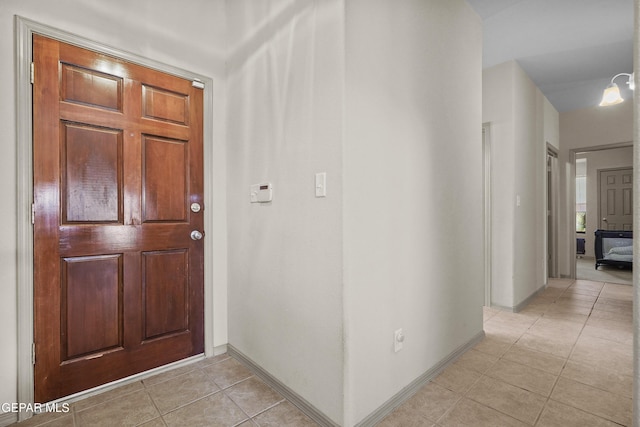 entryway with light tile patterned floors and baseboards