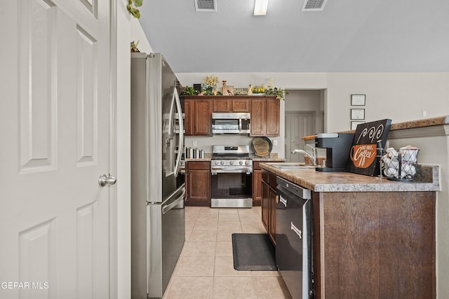 kitchen with stainless steel appliances, light tile patterned floors, visible vents, a sink, and light countertops