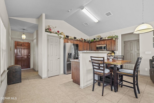 kitchen with light tile patterned floors, stainless steel appliances, visible vents, and vaulted ceiling