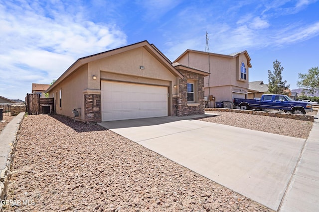 ranch-style home featuring driveway, fence, a garage, stucco siding, and stone siding
