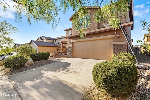7337 Autumn Sage Dr, El Paso, TX 79911 - view of front facade with stone siding, stucco siding, an attached garage, and concrete driveway