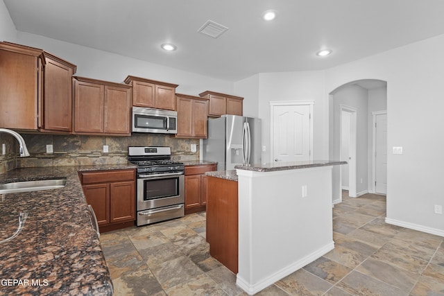 7337 Autumn Sage Dr, El Paso, TX 79911 - kitchen featuring stainless steel appliances, arched walkways, light stone finish flooring, backsplash, and recessed lighting