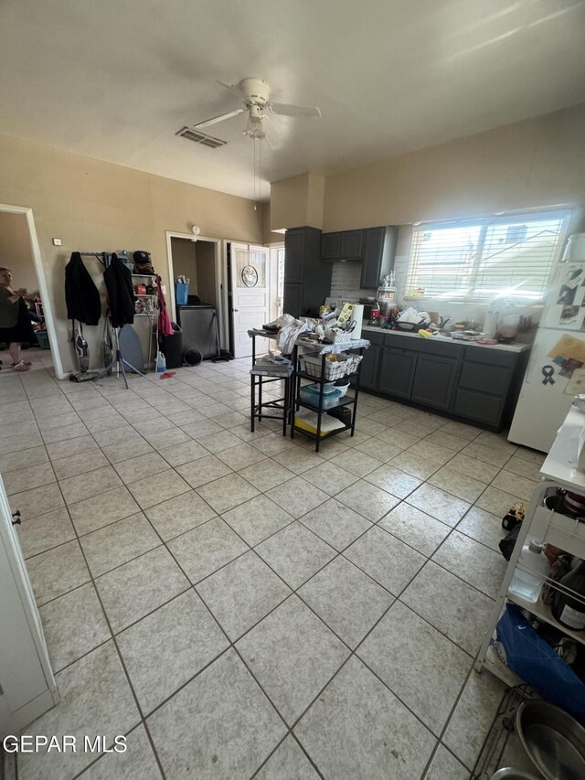 kitchen with visible vents, freestanding refrigerator, light tile patterned flooring, gray cabinets, and a ceiling fan