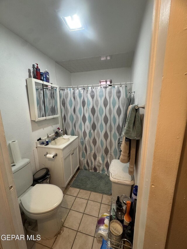 full bath featuring vanity, tile patterned floors, toilet, and curtained shower