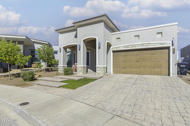 668 Darlington, El Paso, TX 79928 - mediterranean / spanish home with stone siding, stucco siding, an attached garage, and decorative driveway