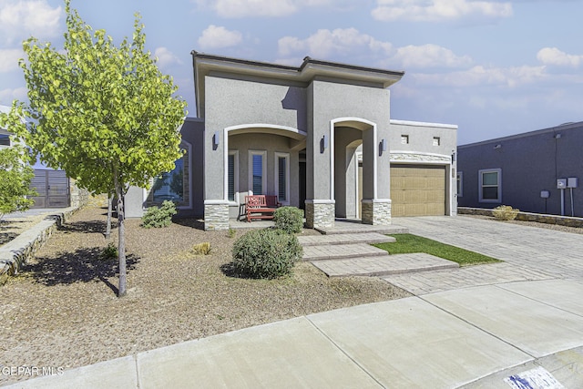 668 Darlington, El Paso, TX 79928 - view of front facade featuring a porch, an attached garage, stone siding, stucco siding, and decorative driveway
