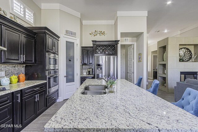 668 Darlington, El Paso, TX 79928 - kitchen with appliances with stainless steel finishes, a sink, open floor plan, wood finished floors, and an island with sink