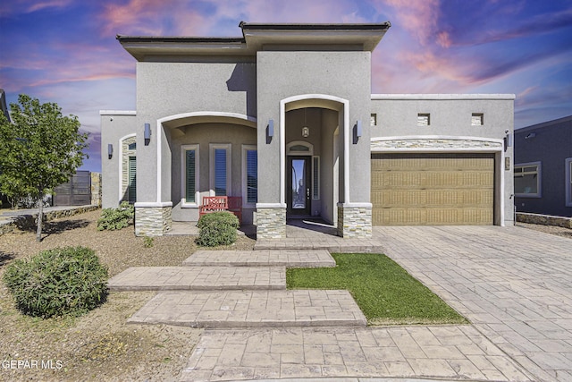 668 Darlington, El Paso, TX 79928 - view of front of house featuring an attached garage, covered porch, stone siding, stucco siding, and decorative driveway