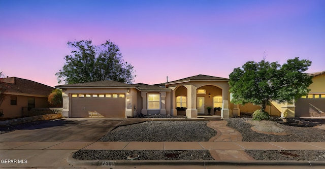 mediterranean / spanish-style home featuring concrete driveway, a garage, stucco siding, and covered porch