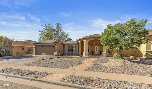 mediterranean / spanish house featuring stucco siding, concrete driveway, and an attached garage