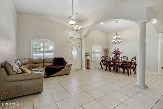 living room with an inviting chandelier, light tile patterned flooring, high vaulted ceiling, ornate columns, and arched walkways