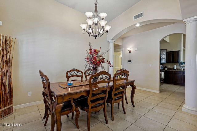dining space featuring light tile patterned floors, visible vents, arched walkways, ornate columns, and a notable chandelier