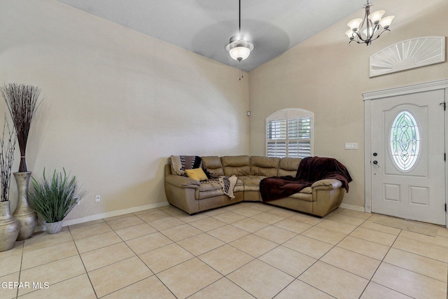 living room with an inviting chandelier, light tile patterned flooring, lofted ceiling, and baseboards