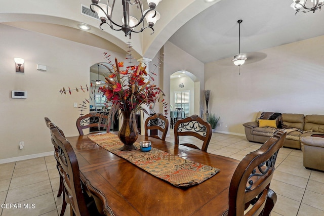 dining room with baseboards, arched walkways, ceiling fan with notable chandelier, and light tile patterned flooring
