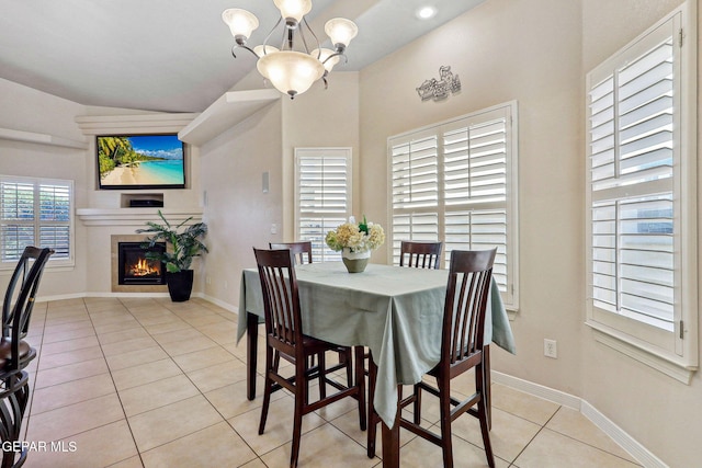 dining room featuring baseboards, light tile patterned floors, a notable chandelier, and a tile fireplace