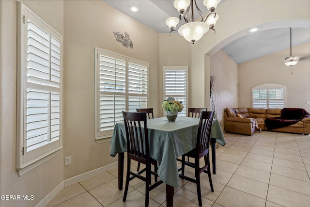 dining area featuring an inviting chandelier, light tile patterned floors, baseboards, and arched walkways
