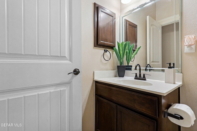 bathroom featuring a textured wall and vanity