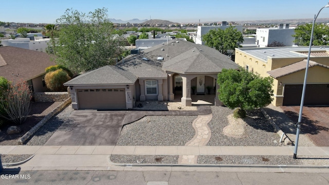 view of front of house with driveway, a residential view, stucco siding, a porch, and a garage
