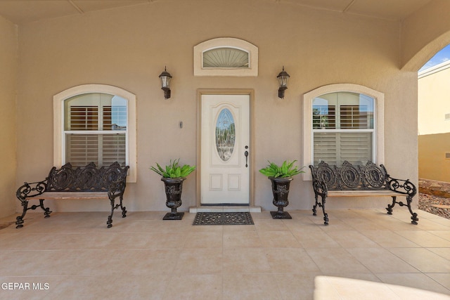 entrance to property featuring stucco siding and a porch