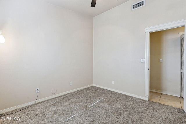 carpeted empty room with baseboards, visible vents, and ceiling fan