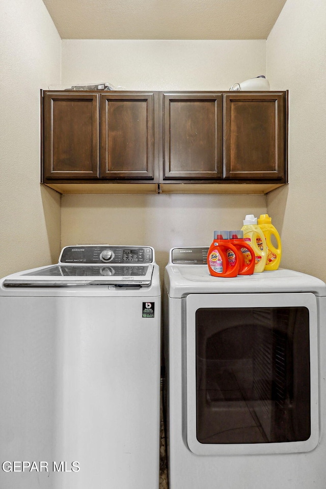laundry area featuring independent washer and dryer and cabinet space