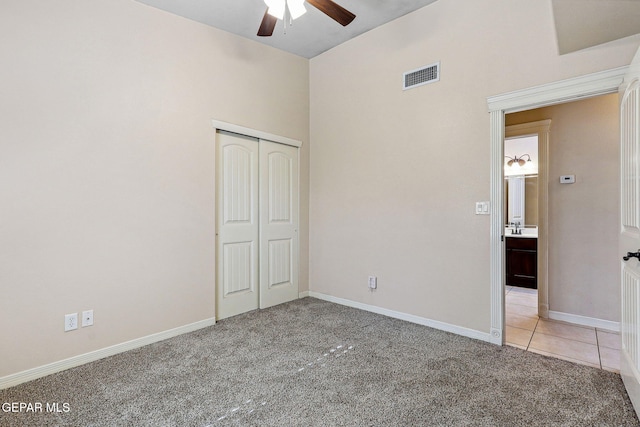 unfurnished bedroom featuring carpet floors, a closet, baseboards, visible vents, and a ceiling fan