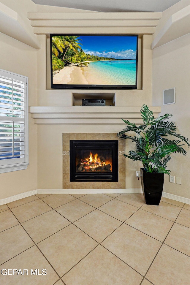 room details featuring a tiled fireplace and baseboards