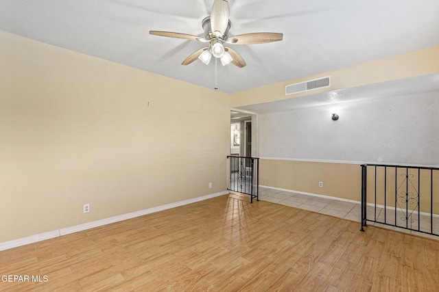 spare room with visible vents, baseboards, ceiling fan, and wood finished floors