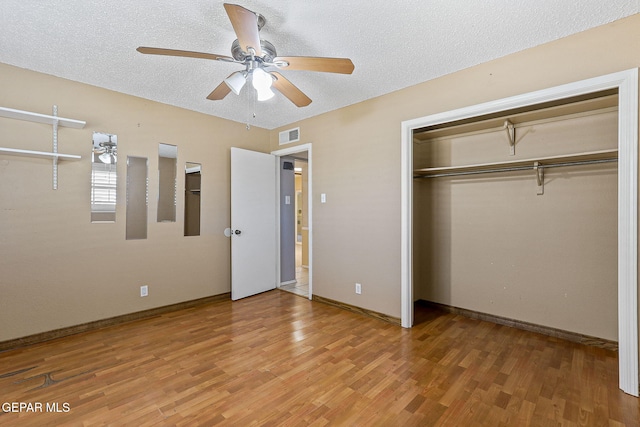 unfurnished bedroom featuring visible vents, a textured ceiling, light wood finished floors, and baseboards