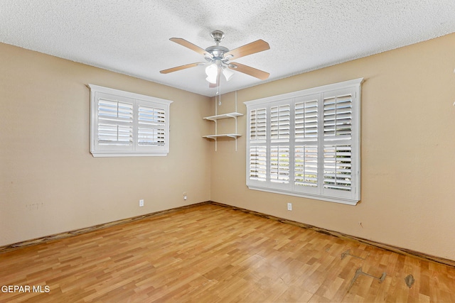 spare room featuring baseboards, a ceiling fan, a textured ceiling, and wood finished floors