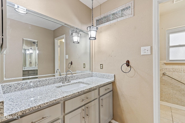 bathroom featuring vanity, a textured wall, and tile patterned floors