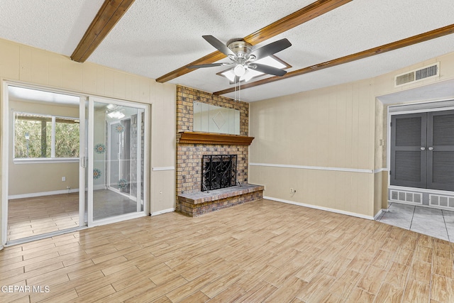 unfurnished living room featuring visible vents, a ceiling fan, beam ceiling, and wood finished floors